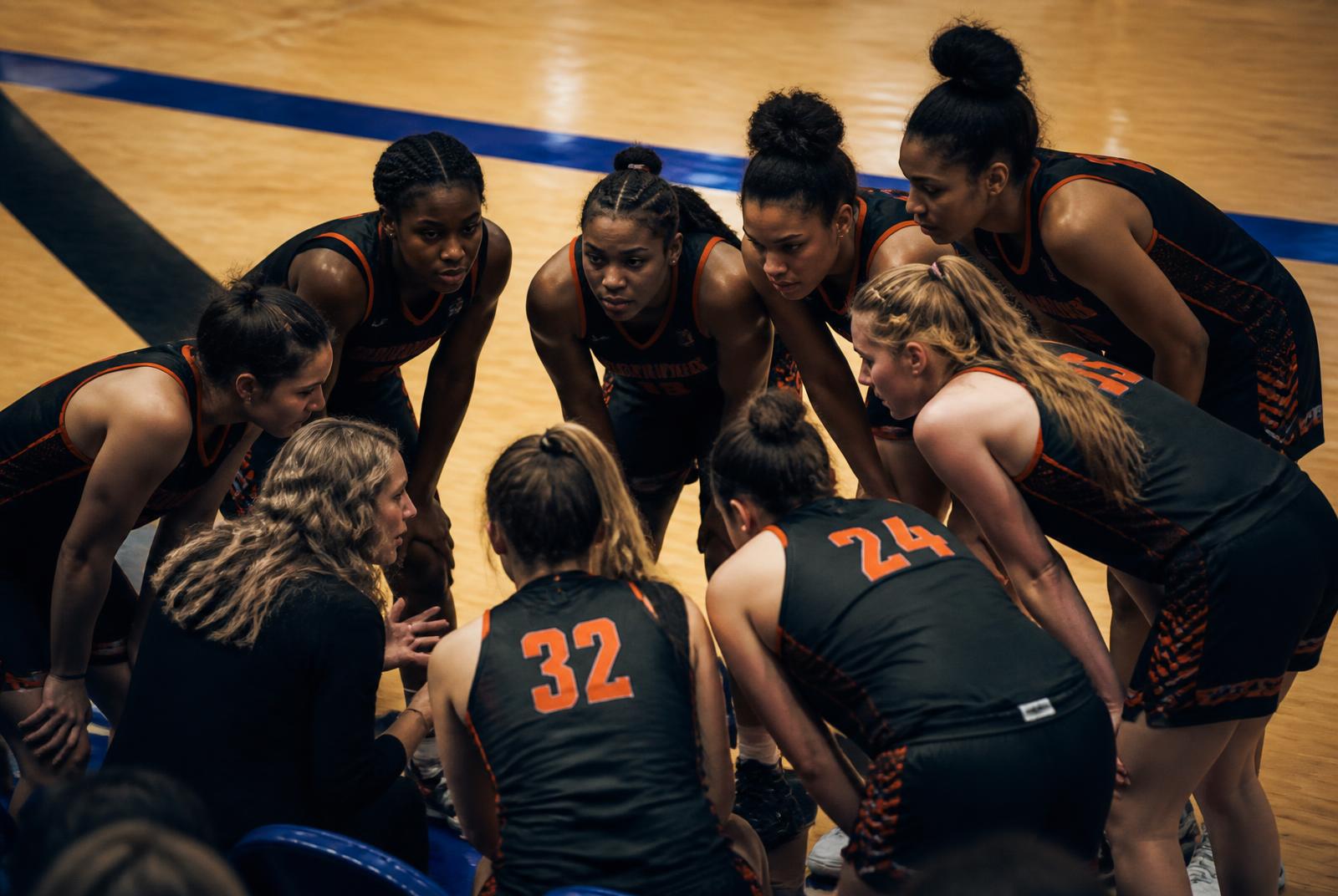 Basketball team gathered in a huddle